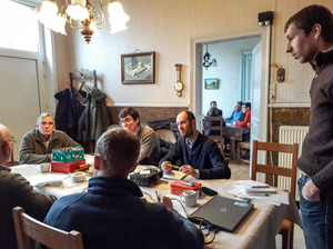 A group of men is sitting/standing at a table.